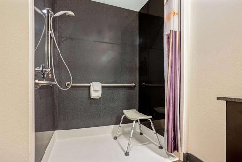 a shower with a chair in a bathroom at La Quinta by Wyndham Tumwater - Olympia in Tumwater