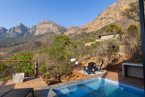 a villa with a pool and mountains in the background at Marepe Mountain View in Kampersrus AH