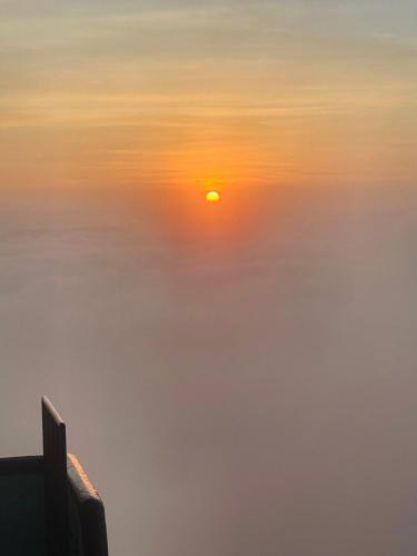 a sunset in the clouds with the sun in the horizon at Singh Brothers in Adams Peak