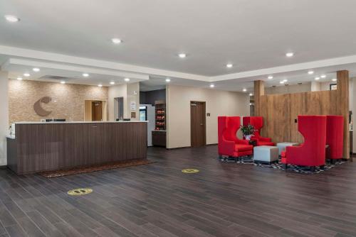 a lobby with red chairs and a reception desk at Comfort Inn & Suites Downtown near University in Tuscaloosa