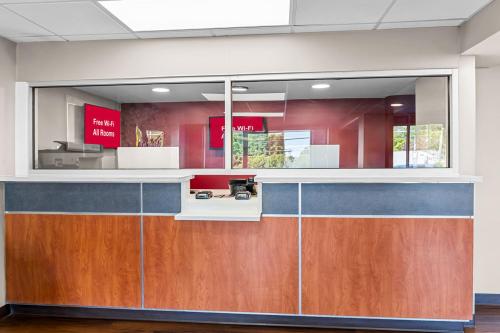 an office lobby with a reception counter with wood at HomeTowne Studios by Red Roof Richmond - Airport Sandston in Sandston