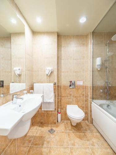 a bathroom with a sink and a toilet and a tub at SOL by Meliá Luna Bay Resort - All Inclusive in Obzor