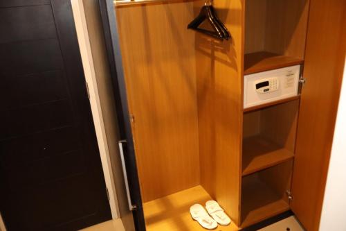 a small closet with two pairs of shoes in it at The Victoria Hotel Yogyakarta in Yogyakarta