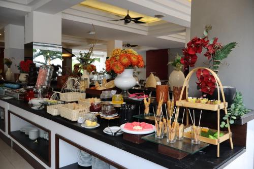 a buffet line with food on display in a restaurant at The Victoria Hotel Yogyakarta in Yogyakarta
