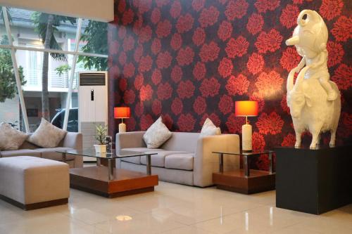 a lobby with a living room with a couch and a statue at The Victoria Hotel Yogyakarta in Yogyakarta