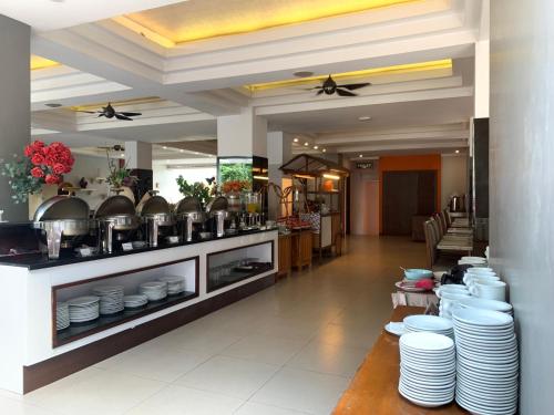 a restaurant with white dishes on display in a kitchen at The Victoria Hotel Yogyakarta in Yogyakarta