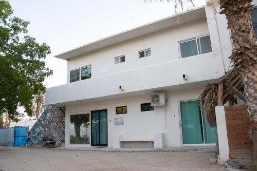 a white building with green doors at Habitación Confortable Cerca del Mar in La Paz