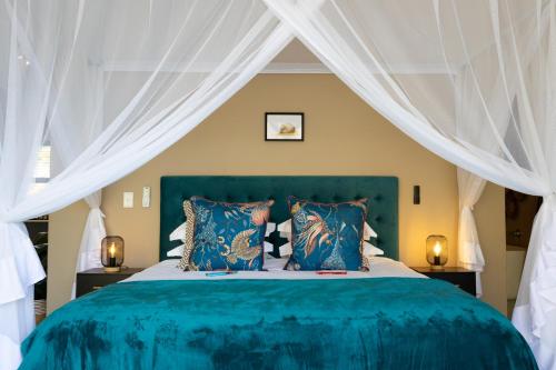 a bedroom with a blue bed with white curtains at Marepe Mountain View in Kampersrus AH