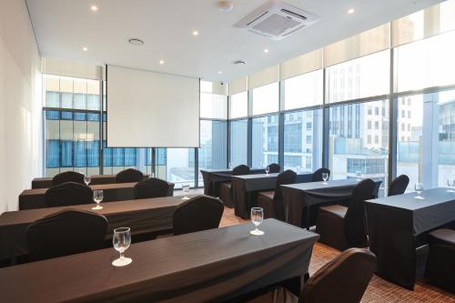a restaurant with tables and chairs and large windows at Stanford Hotel Myeongdong in Seoul
