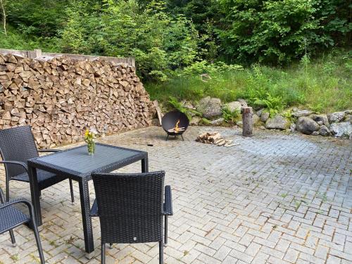 a patio with a table and chairs and a fire pit at Apartmány Pstruží AP19 in Pstruží