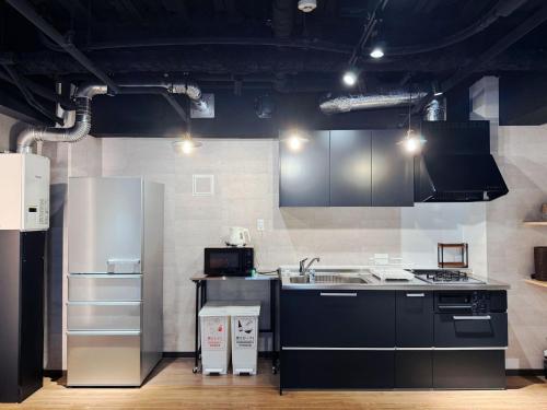 a kitchen with a stove and a refrigerator at IKEBUKURO TOKIWA 10 BUILDING 6min walk from Ikebukuro Station Direct access to the airport in Tokyo
