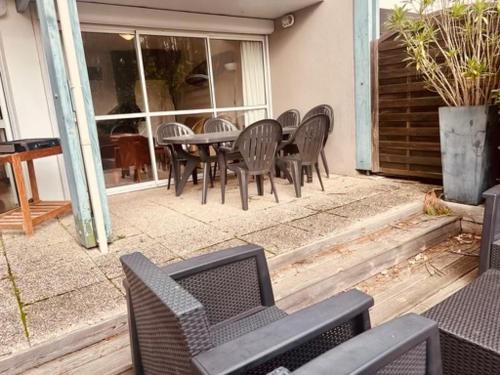 un groupe de chaises et une table sur une terrasse dans l'établissement maison lacanau ocean, à Lacanau