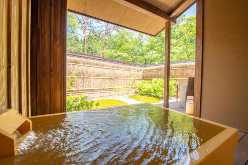 a room with a large window and a pool of water at Shionoyu Onsen Rengetsu in Nasushiobara