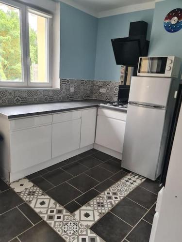 une cuisine avec des armoires blanches et un réfrigérateur blanc dans l'établissement Appartement centre du village, à Flassans-sur-Issole