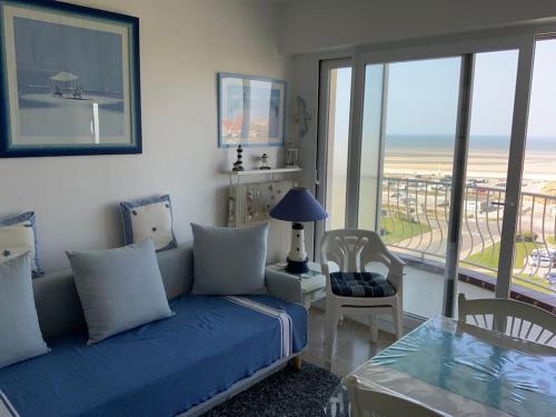 a bedroom with a bed and a table with a view of the ocean at Studio, nid douillet, face mer 2 pers in Le Touquet-Paris-Plage