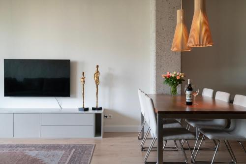 a dining room with a table and a tv on a wall at Trendy crib in city centre Rotterdam in Rotterdam