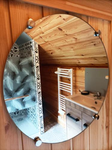 - un miroir sur un mur en bois dans l'établissement Kota 'Dans les étoiles', à Merlines