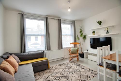 a living room with a couch and a table at London Serviced Accommodation near Tottenham Hotspurs Football Stadium Great for Contractors in London