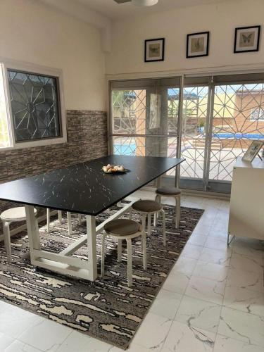 a dining room with a black table and chairs at Sendou Cabano Villa Retreat in Siendou