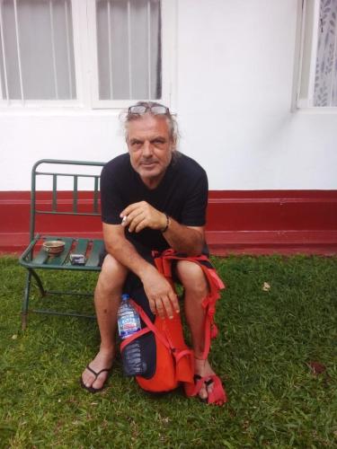 a man sitting on a bench in the grass at No 06 Veediya Bandara Lane Bahirawakanda in Kandy