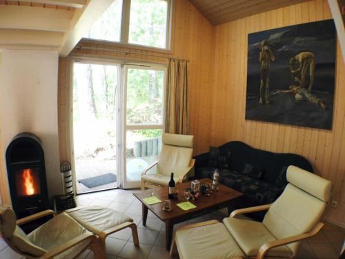 a living room with a couch and chairs and a fireplace at Hagebutte - Baabe in Baabe