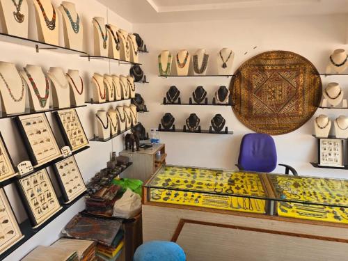 a store with a shelf of hats and a table at Hotel Badami Court in Badami