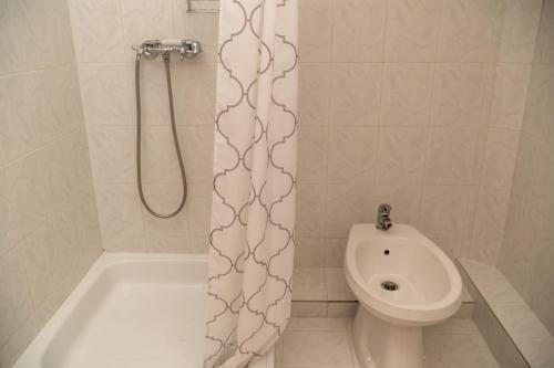 a bathroom with a toilet and a shower curtain at Mazsola Vendégház in Tamási