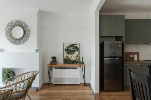 a kitchen with a refrigerator and a table with chairs at Modern 3-Bed Coastal Escape in Burnie