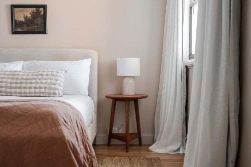 a bedroom with a bed and a table with a lamp at Modern 3-Bed Coastal Escape in Burnie