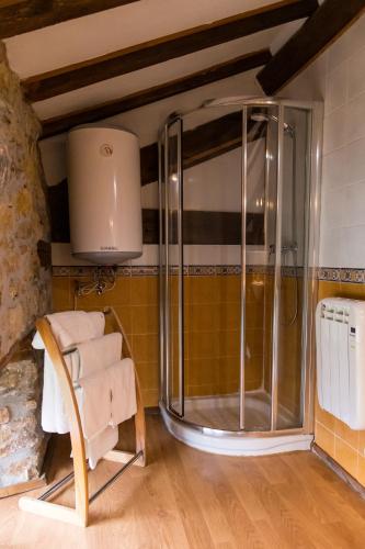 a glass shower in a room with a chair at Errotazar apartamento rural K in Alsasua