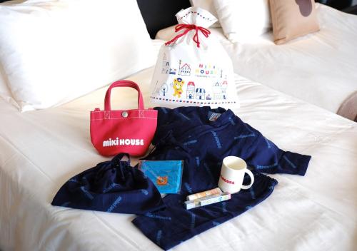 a pile of clothes and a bag on a bed at Hotel Monterey Okinawa Spa & Resort in Onna
