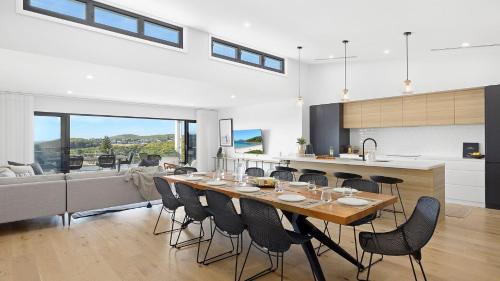 a dining room and kitchen with a table and chairs at Ocean Scene in Fingal Bay