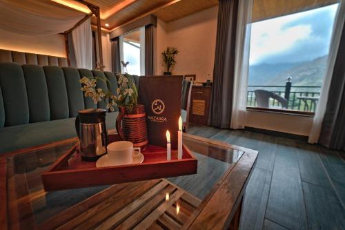 a living room with a table with candles and a couch at Nazaara - A Luxe Retreat in Manāli