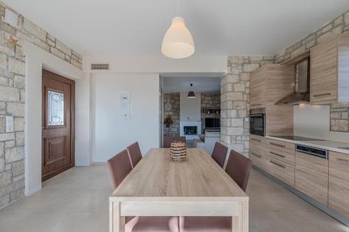 a kitchen with a wooden table and chairs at Petrina 3 villa by the sea in Keratokampos