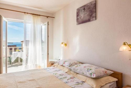a bedroom with a bed and a view of the ocean at Apartments and Rooms Happiness in Tučepi