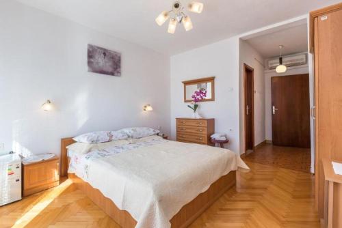 a bedroom with a bed and a dresser in it at Apartments and Rooms Happiness in Tučepi