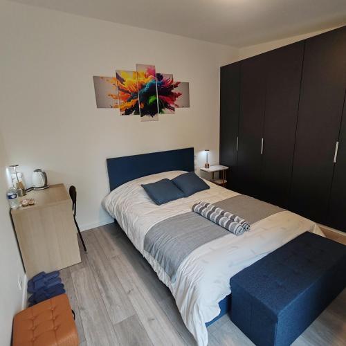 a bedroom with a large bed with a blue ottoman at Le patio Aristide in Champigny-sur-Marne