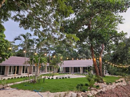 a house with lights and trees in front of it at Bunyagard Koh Kood Resort in Ban Lak Uan
