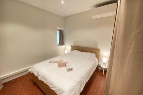 - une chambre avec un lit blanc et un peignoir rose dans l'établissement 06CF Beautiful renovated apartment in old Antibes, à Antibes