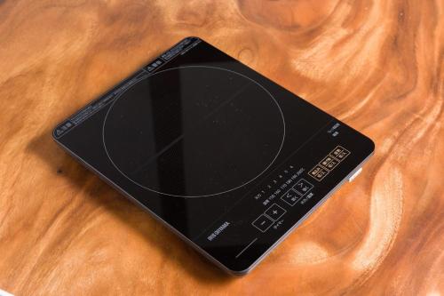 a black remote control sitting on top of a wooden table at FARMSTAY miyuki-street "Hotaru" in Kugumiya