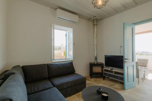 a living room with a couch and a tv at Dipaton House in Vasa 2 in Vasa Kilaniou