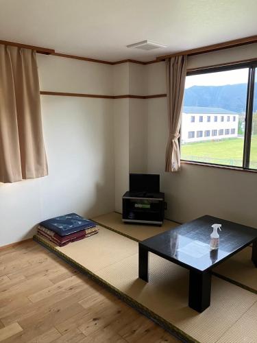 a living room with a table and a window at WASUKIBASEびわ湖GuestHouse in Kaizu