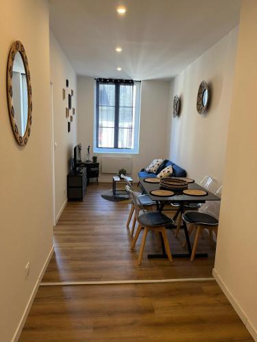 un salon avec une table et un canapé dans l'établissement Appartement confortable, neuf en centre ville, à Cany-Barville