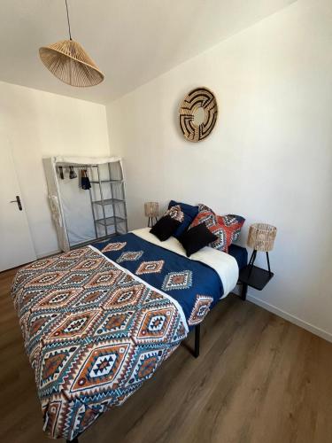 une chambre avec un lit et une horloge au mur dans l'établissement Appartement confortable, neuf en centre ville, à Cany-Barville