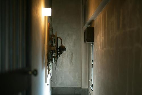a hallway with a light on a wall and a lamp at Toyooka1925 in Toyooka