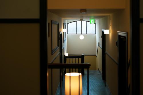 a hallway with a door and a window and a light at Toyooka1925 in Toyooka