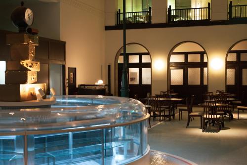 a room with tables and chairs and a clock on the wall at Toyooka1925 in Toyooka