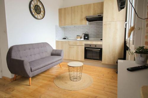 un salon avec un canapé et une table dans l'établissement NEW! Saint Martin 52A- Grand studio lumineux-wifi, à Angoulême
