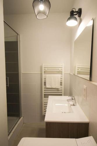 une salle de bain blanche avec un lavabo et un miroir dans l'établissement NEW! Saint Martin 52A- Grand studio lumineux-wifi, à Angoulême