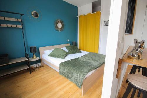 une chambre avec un lit et un mur bleu dans l'établissement NEW! Saint Martin 52A- Grand studio lumineux-wifi, à Angoulême